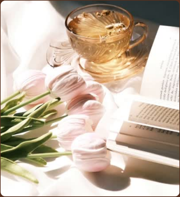 紅茶、本、花を置いたカフェのテーブル